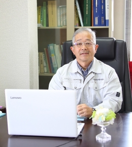 代表の井上哲也が机に座っている写真です。